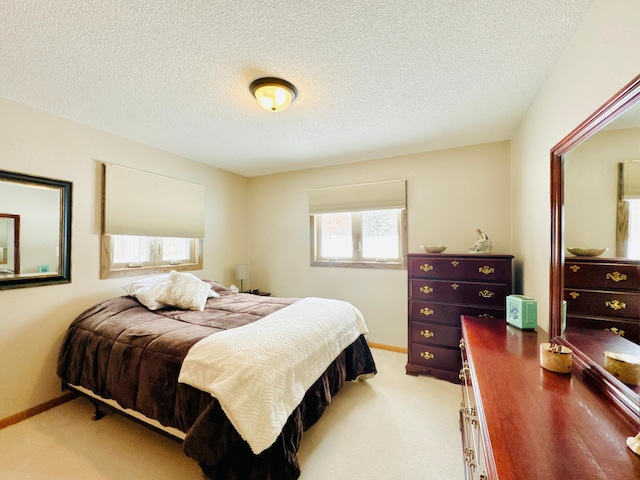 bedroom featuring a textured ceiling and light carpet