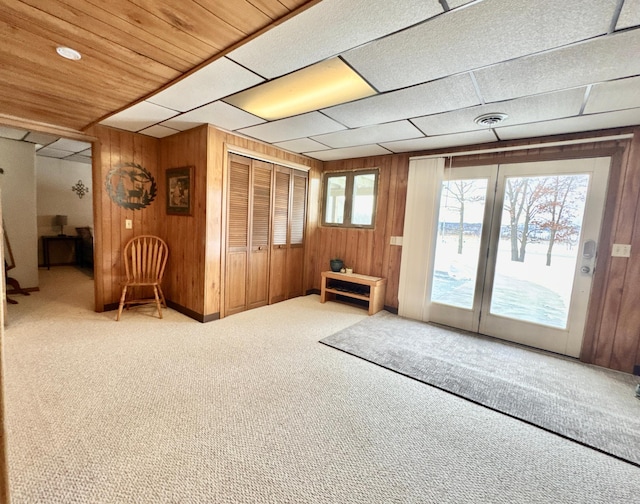 interior space with a water view, carpet, and wooden walls