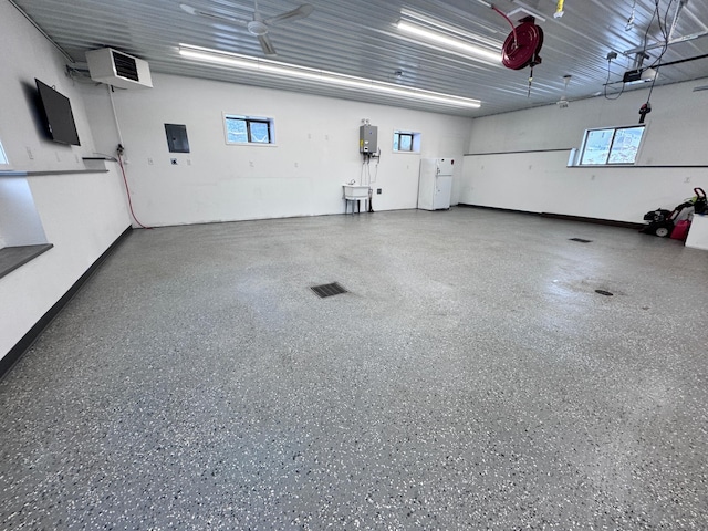 garage with a garage door opener and a wall mounted AC