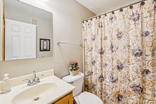 full bath featuring a textured ceiling, toilet, vanity, visible vents, and a shower with curtain