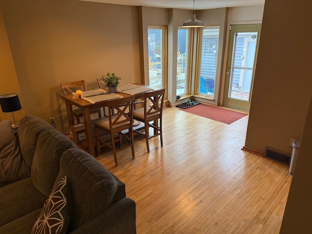 dining space featuring light wood-style floors and visible vents