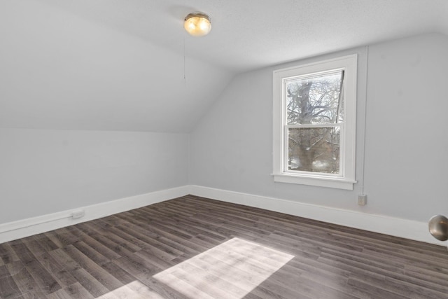 bonus room featuring vaulted ceiling, dark hardwood / wood-style floors, and a textured ceiling