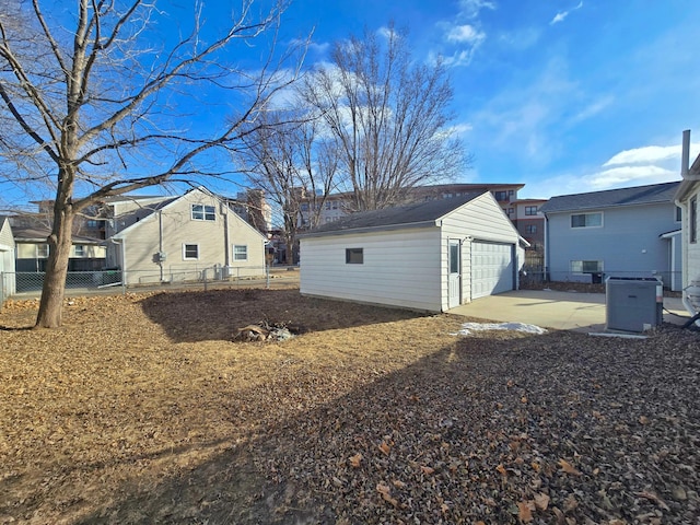 view of yard with a detached garage, a residential view, an outdoor structure, and fence