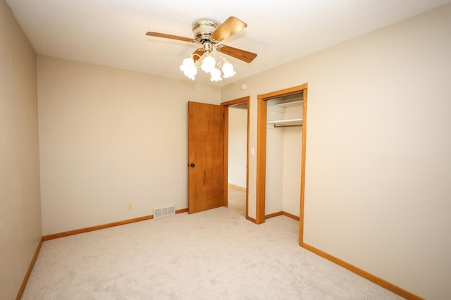 unfurnished bedroom featuring visible vents, baseboards, light colored carpet, a closet, and a ceiling fan