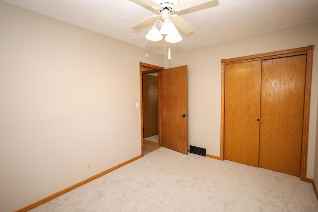 unfurnished bedroom with a ceiling fan, carpet flooring, baseboards, and visible vents