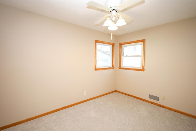 unfurnished room featuring light carpet, visible vents, ceiling fan, and baseboards