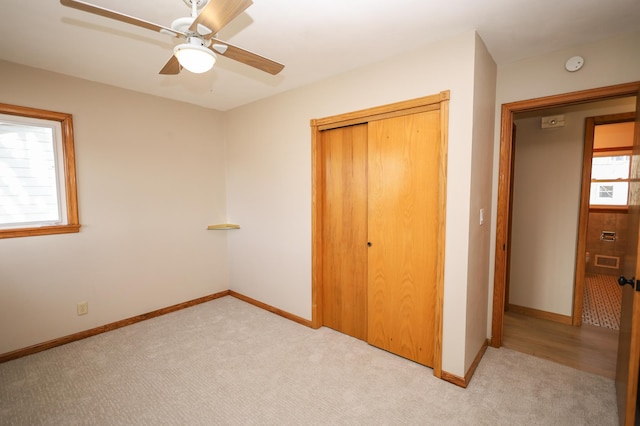 unfurnished bedroom with light colored carpet, baseboards, and a closet