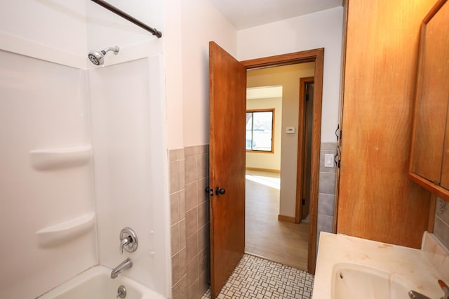 full bath featuring tile patterned flooring,  shower combination, and a sink