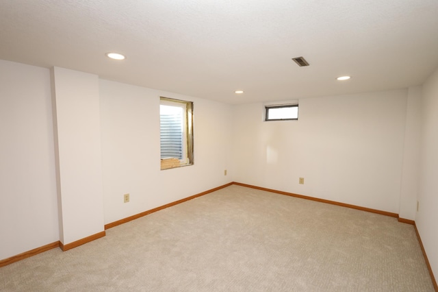 empty room with recessed lighting, light colored carpet, visible vents, and baseboards