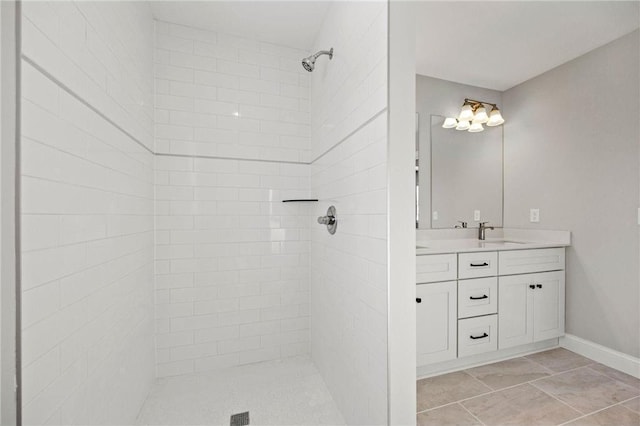 bathroom featuring tiled shower and vanity