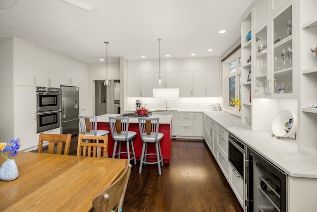 kitchen with a kitchen island, white cabinets, stainless steel appliances, and a sink