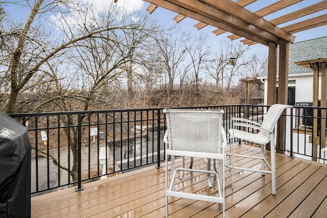 wooden deck with grilling area and a pergola