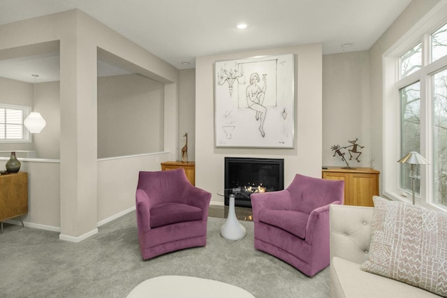 sitting room with recessed lighting, baseboards, carpet, and a lit fireplace