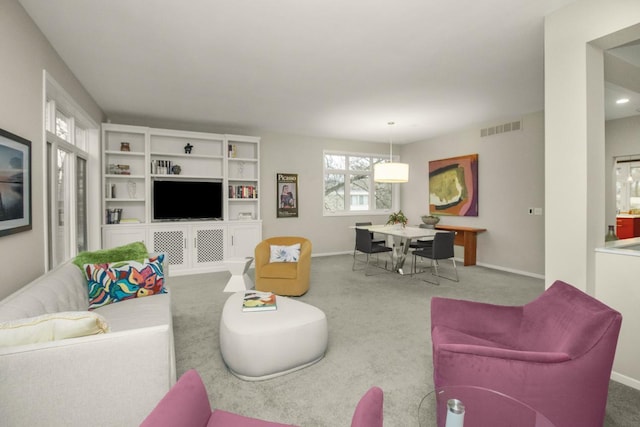 carpeted living room featuring visible vents and baseboards