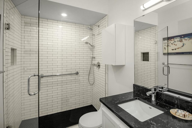 full bathroom with toilet, a stall shower, and vanity