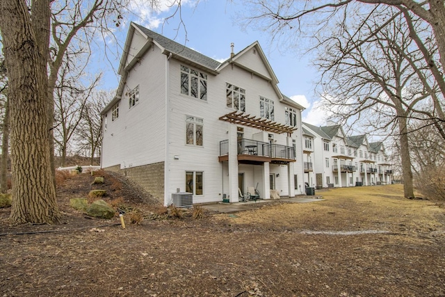 rear view of house featuring a patio, central AC unit, and a pergola