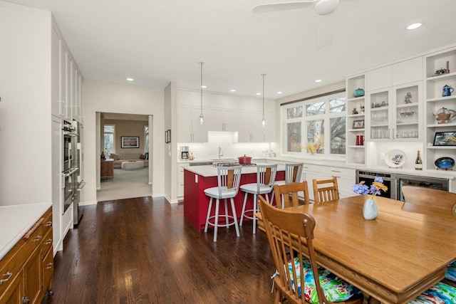 dining room featuring dark wood-style floors, recessed lighting, beverage cooler, and ceiling fan