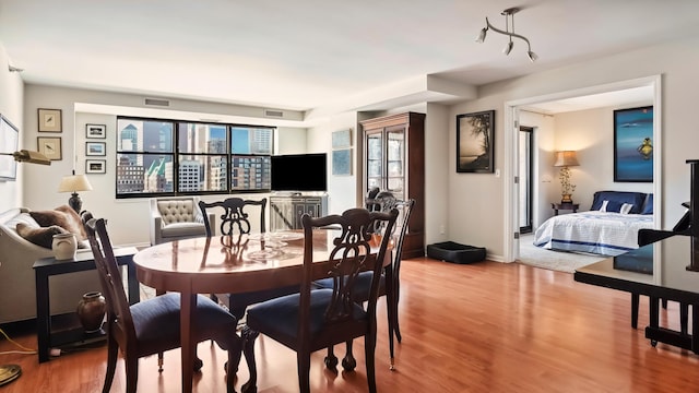 dining area featuring baseboards, visible vents, and wood finished floors