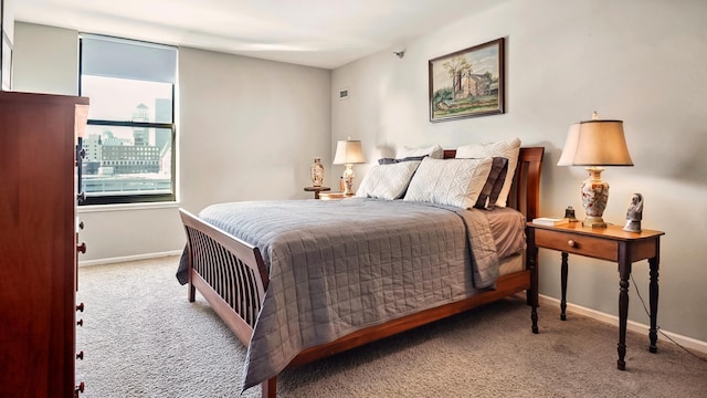 bedroom with carpet, baseboards, and a city view