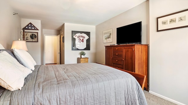 bedroom featuring light colored carpet and baseboards