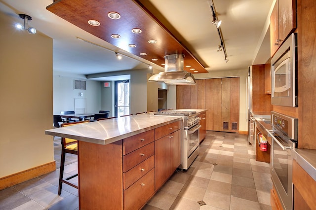 kitchen with visible vents, a kitchen island, island exhaust hood, stainless steel appliances, and light countertops