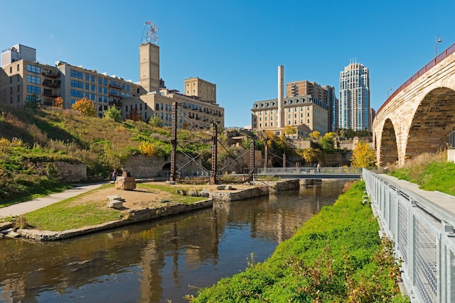 view of home's community featuring a water view, fence, and a city view