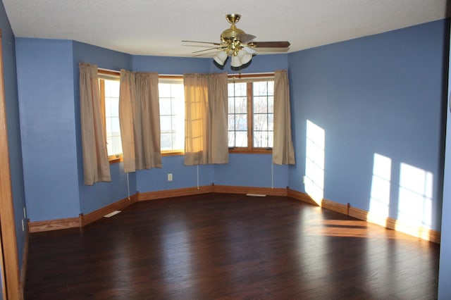 empty room with dark wood-type flooring and ceiling fan