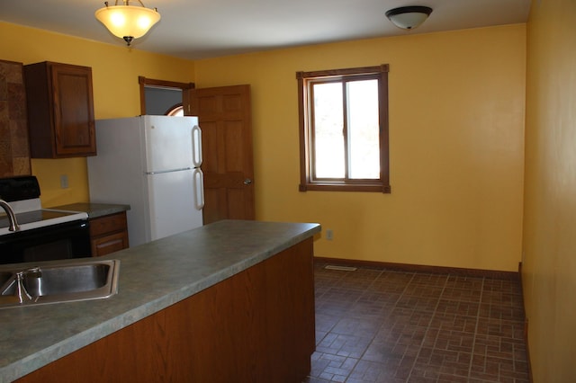 kitchen with white refrigerator, decorative light fixtures, electric stove, and sink