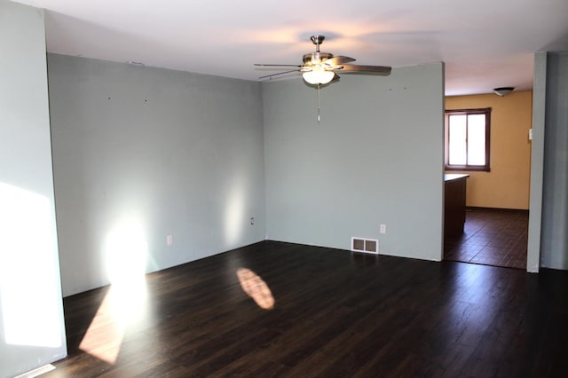 unfurnished room featuring dark wood-type flooring and ceiling fan