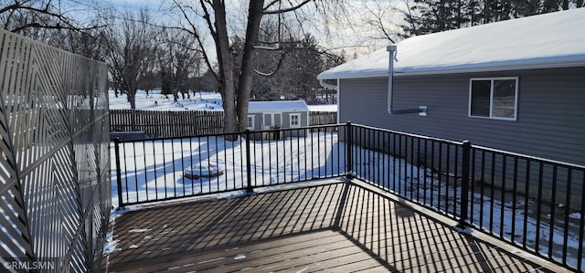 snow covered deck with a pool and a storage unit