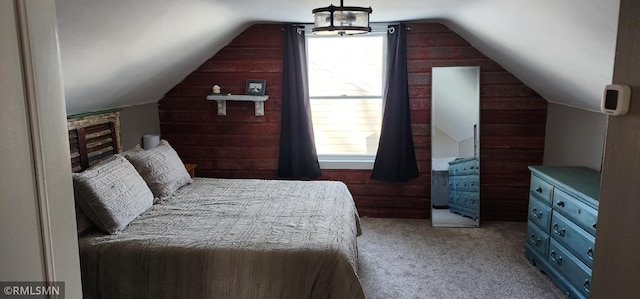 carpeted bedroom with lofted ceiling and wooden walls