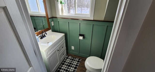 bathroom with hardwood / wood-style flooring, vanity, and toilet