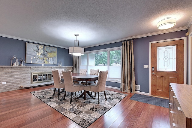 dining room featuring crown molding, dark hardwood / wood-style floors, and a textured ceiling