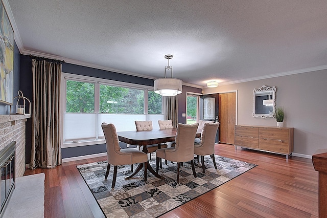 dining space with dark hardwood / wood-style flooring, ornamental molding, and a textured ceiling