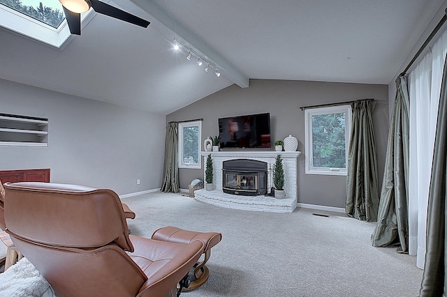 living room featuring vaulted ceiling with skylight and light carpet