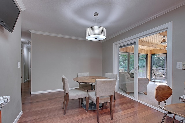 dining room with hardwood / wood-style flooring and crown molding