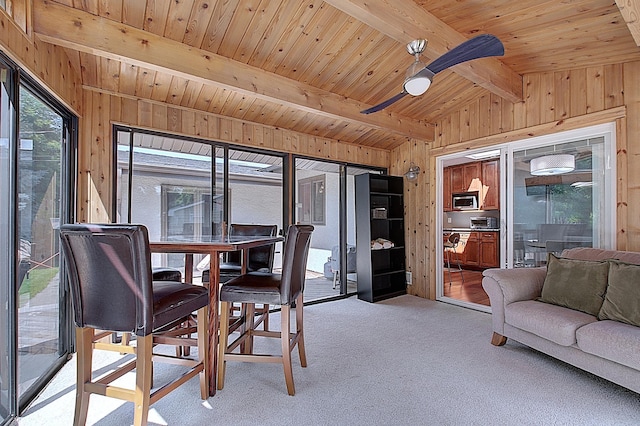 sunroom featuring ceiling fan, lofted ceiling with beams, and wooden ceiling