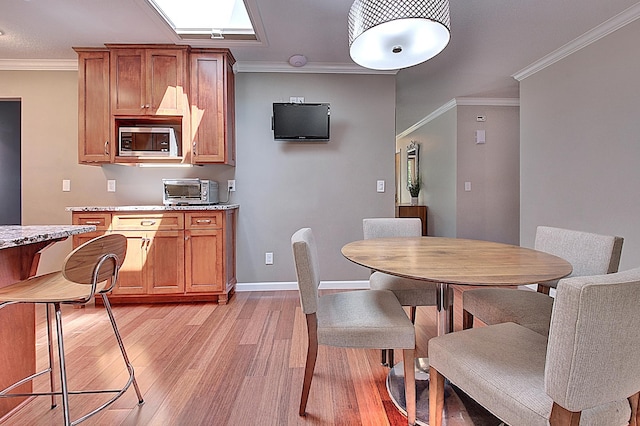 dining area with crown molding and light hardwood / wood-style floors