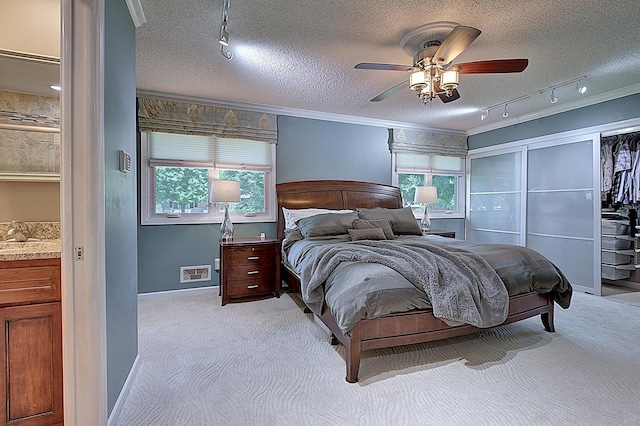 carpeted bedroom with multiple windows, ornamental molding, and a textured ceiling