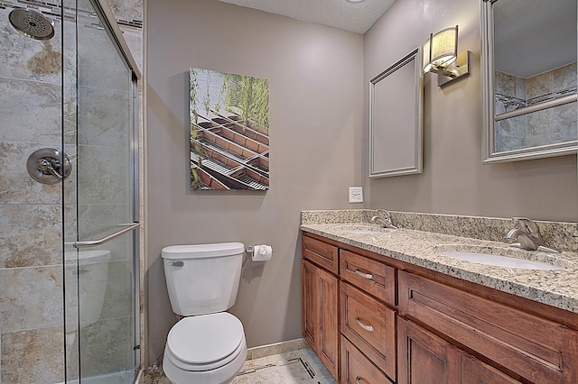 bathroom with vanity, an enclosed shower, a textured ceiling, and toilet