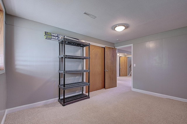 spare room featuring carpet floors and a textured ceiling