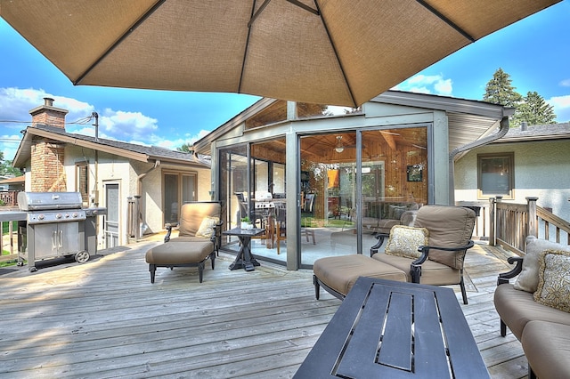 wooden terrace with a grill and a sunroom