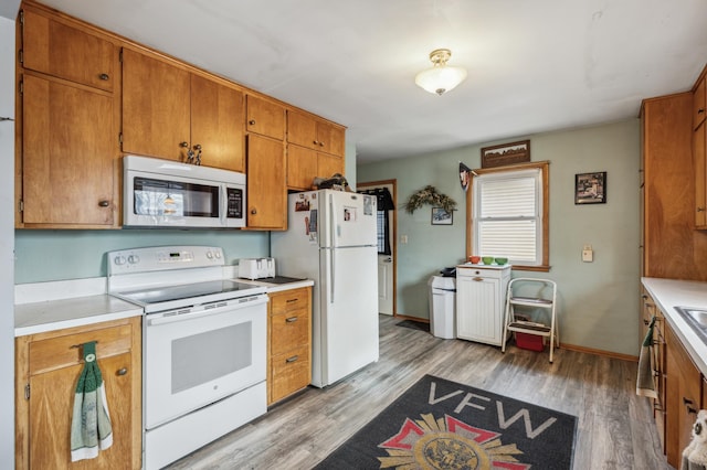 kitchen with white appliances and light hardwood / wood-style floors