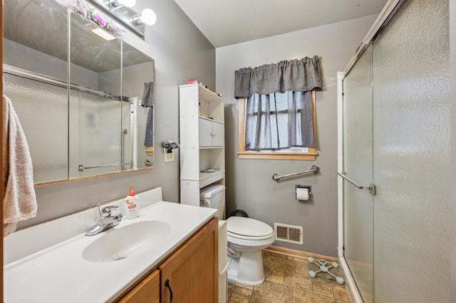 bathroom featuring vanity, toilet, and an enclosed shower