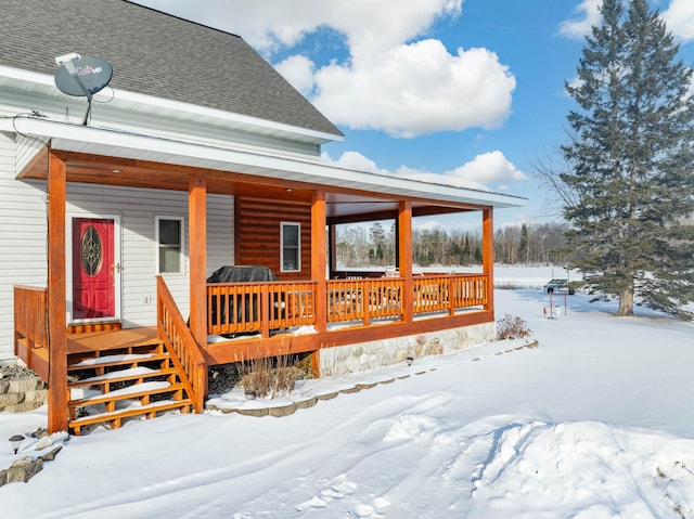 snow covered deck featuring a porch