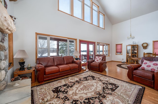 living room featuring high vaulted ceiling, hardwood / wood-style floors, and a chandelier