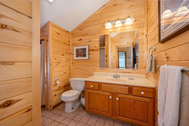 bathroom with wood walls, lofted ceiling, vanity, toilet, and tile patterned floors