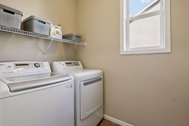 clothes washing area featuring laundry area, washing machine and clothes dryer, and baseboards