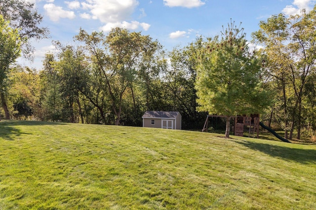 view of yard with a storage unit, a playground, and an outdoor structure