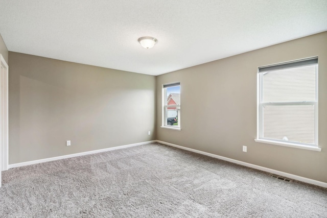 carpeted spare room featuring a textured ceiling